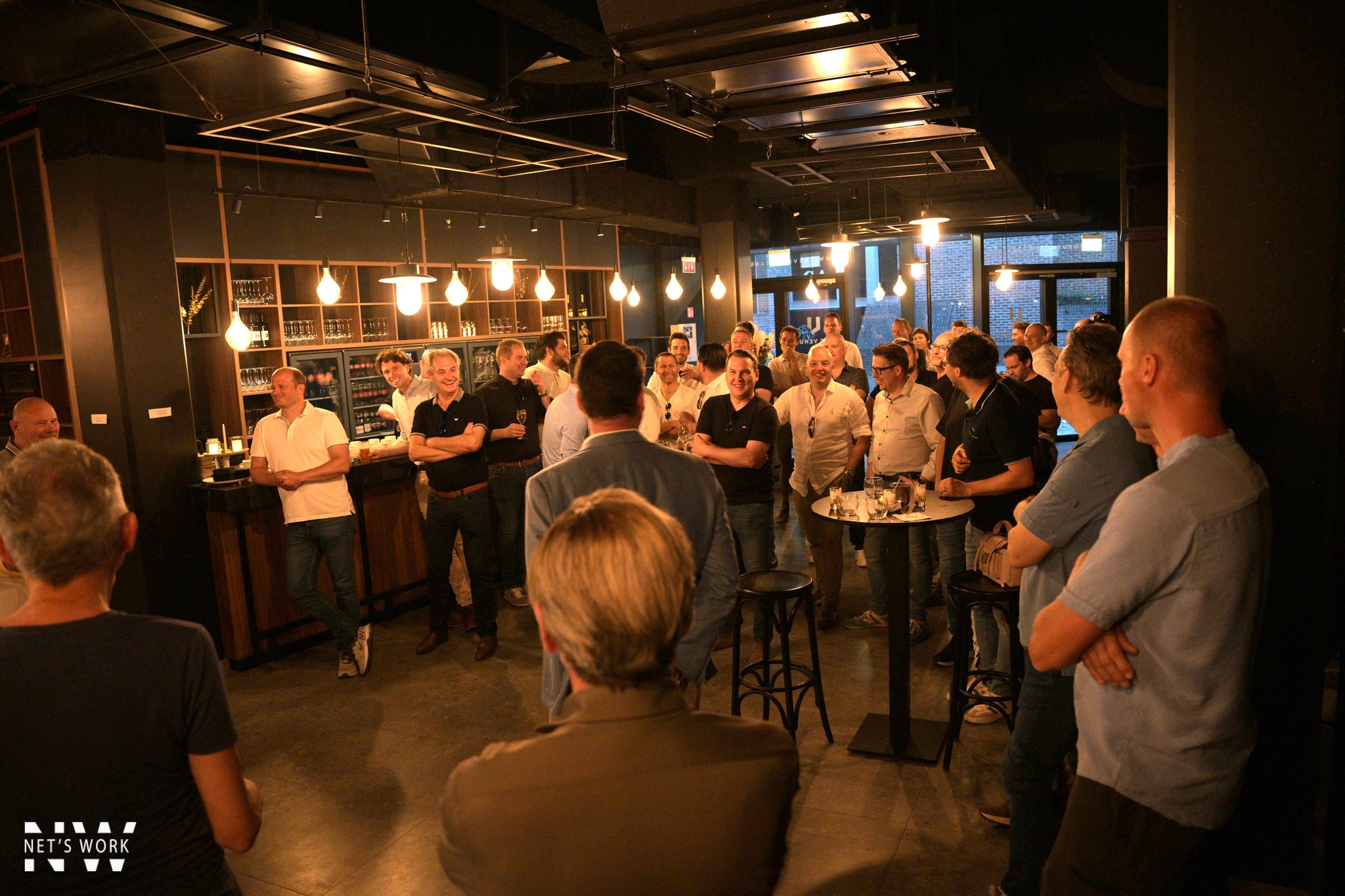 Formeel gala met lange tafel, warme verlichting en gasten in gesprek