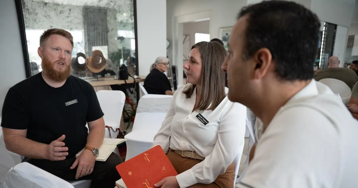 Business professionals discussing referral strategy and networking during a collaborative group session.