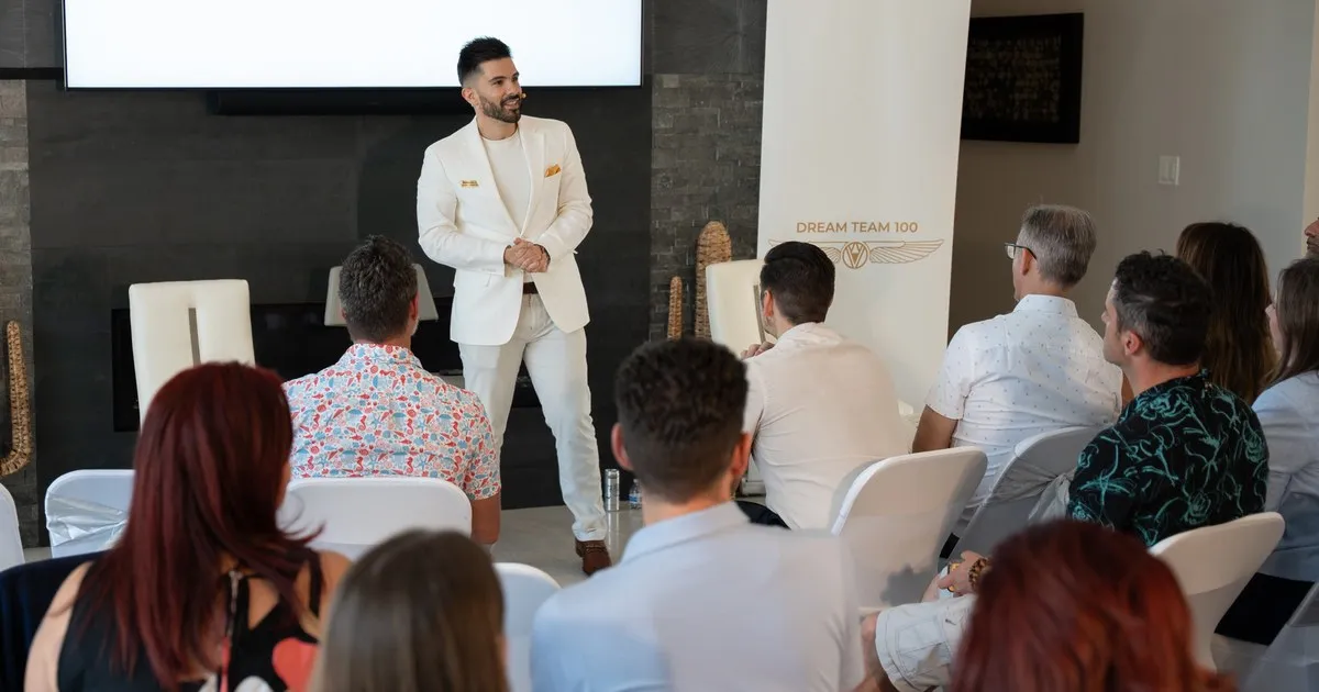 Sebastian Cruze speaking to Dream Team 100 members at the community's April 2026 live event