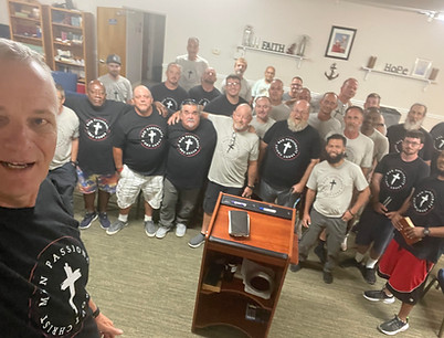 Group of men gathered together at an MPACT Ministries brotherhood meeting, standing in unity and faith inside a community room