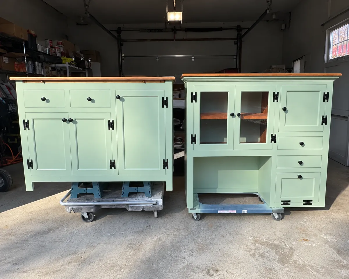Two vintage wooden cabinets refinished in soft mint green paint with natural wood tops and black hardware, showcasing custom furniture refinishing.