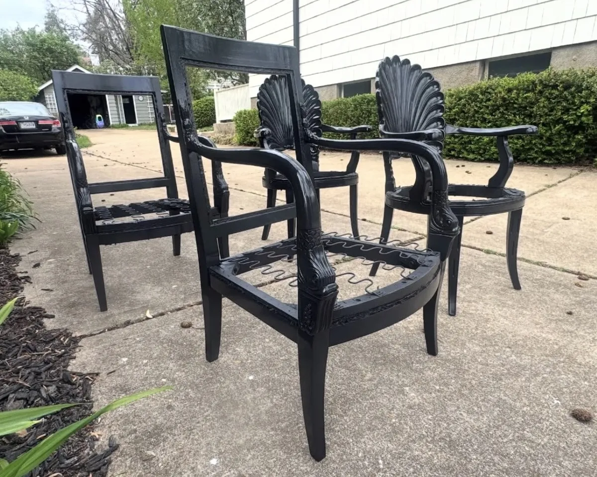 Decorative wooden chairs refinished in a glossy black finish, showcasing furniture painting and detailed restoration work.