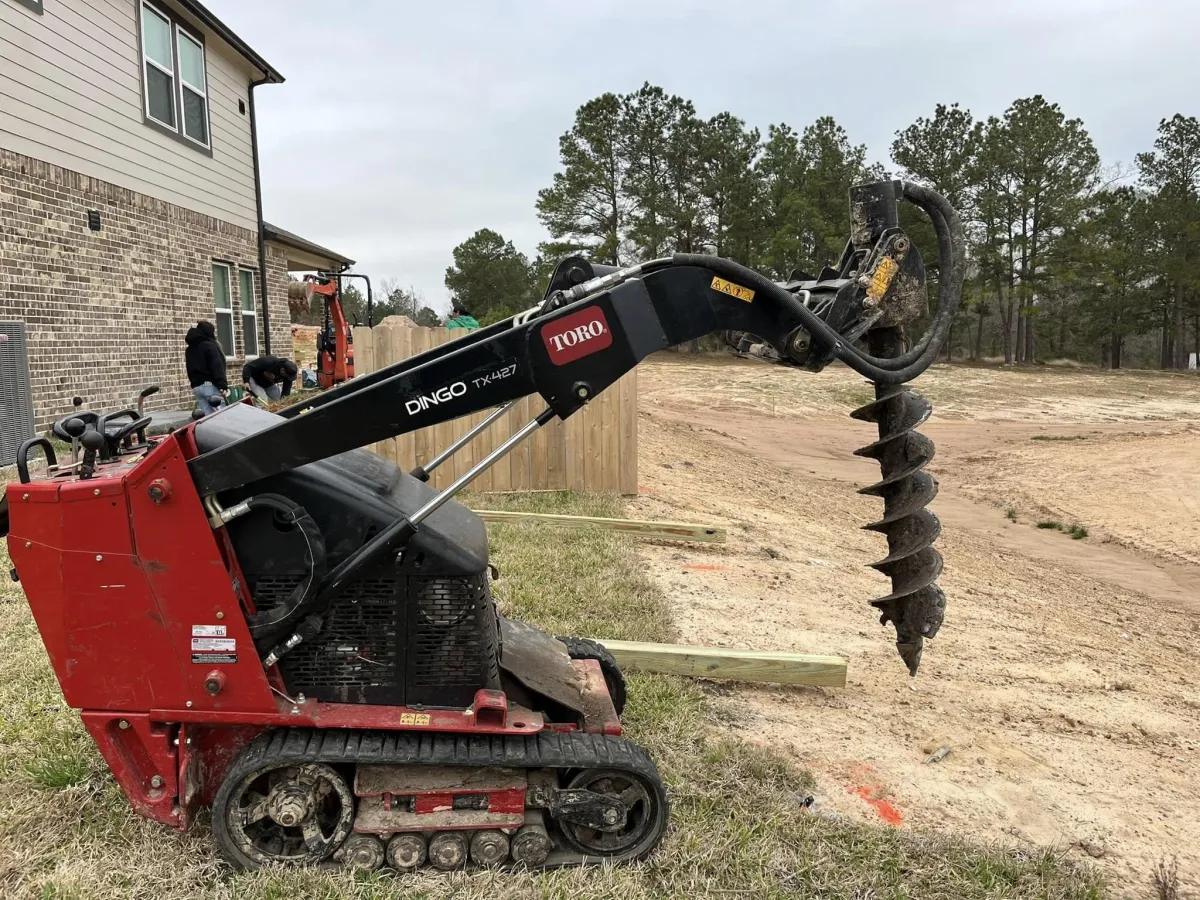 auger hole driller about to drill a hole for a fence line