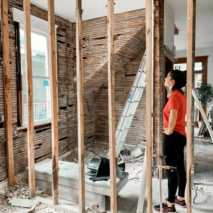Woman with a red shirt standing in new bathroom construct.
