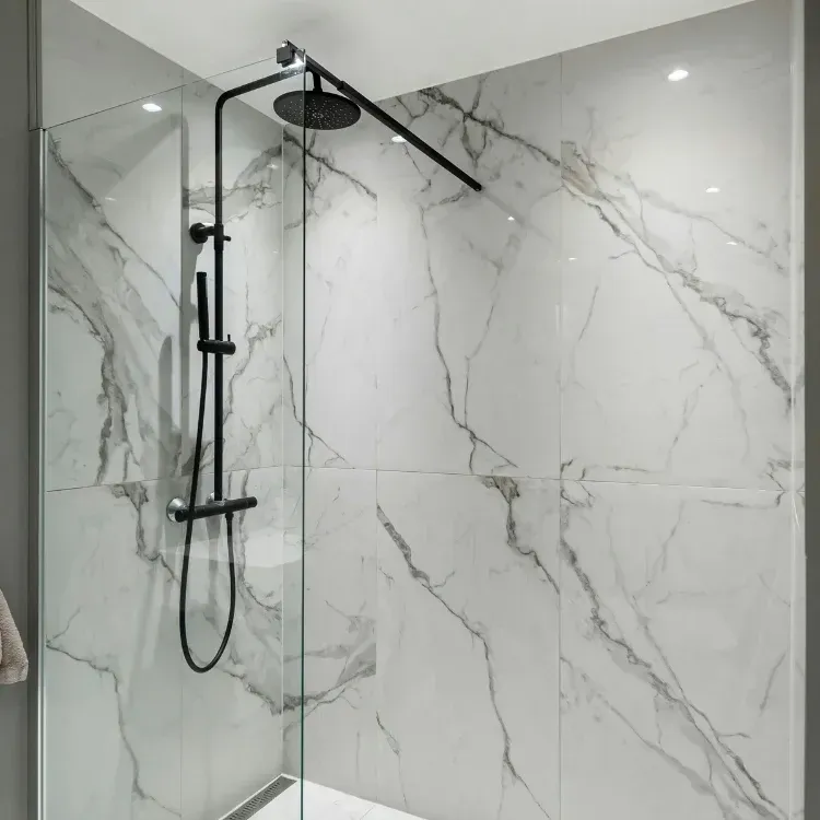 Newly installed tiles, black shower and shower glass.