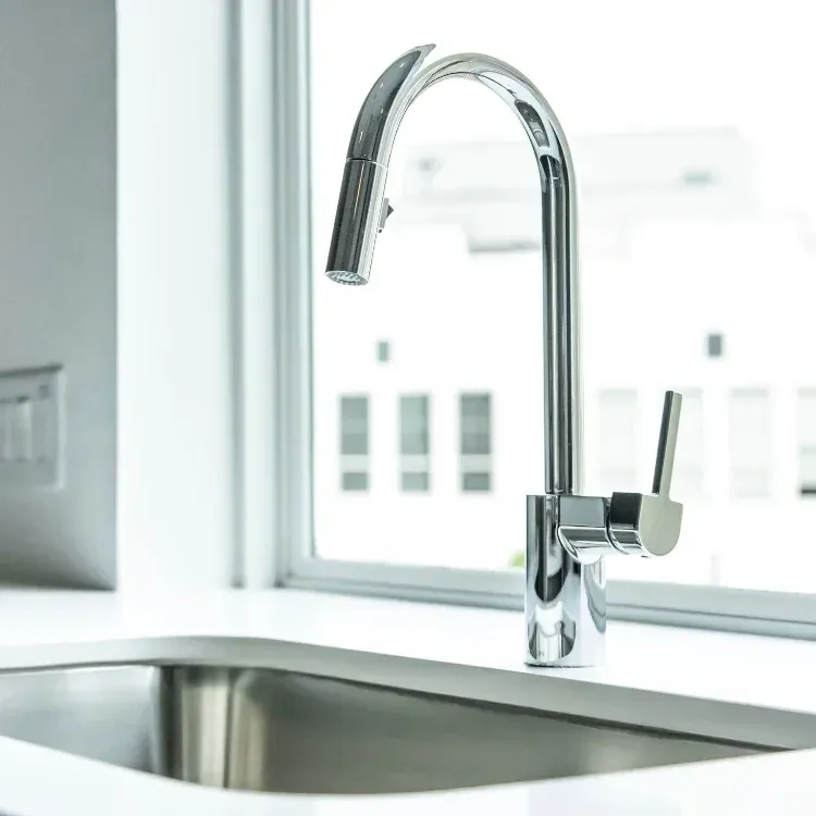 A silver sink on white countertop.