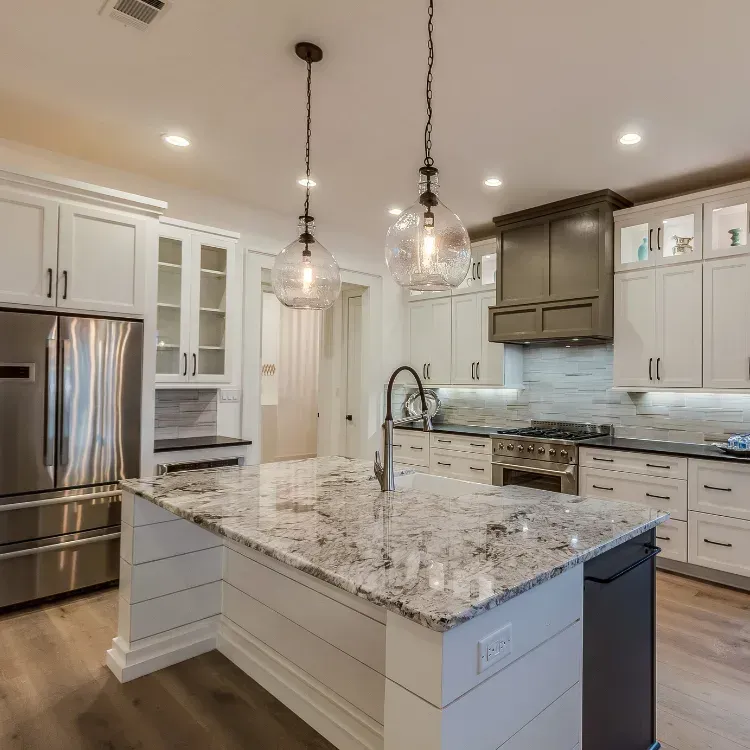 Kitchen island with marble countertop, and overhead hanging light fixture,