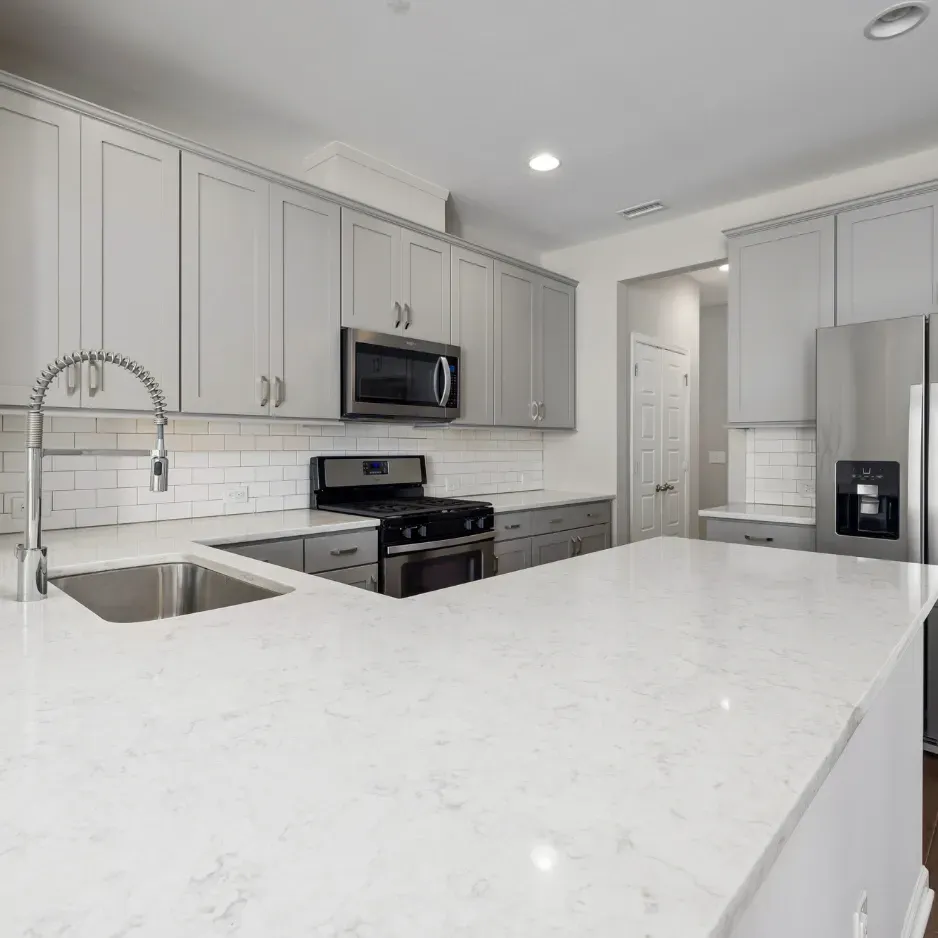 Renovated white marble counter tops, silver sink and white cabinets. 