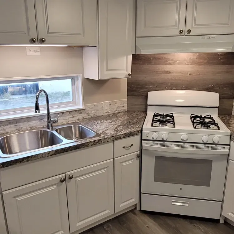 New kitchen build with new countertop, sink and white stove.