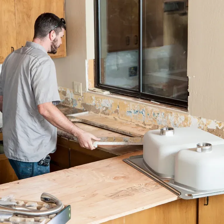 Contractor installing new countertops and sink.