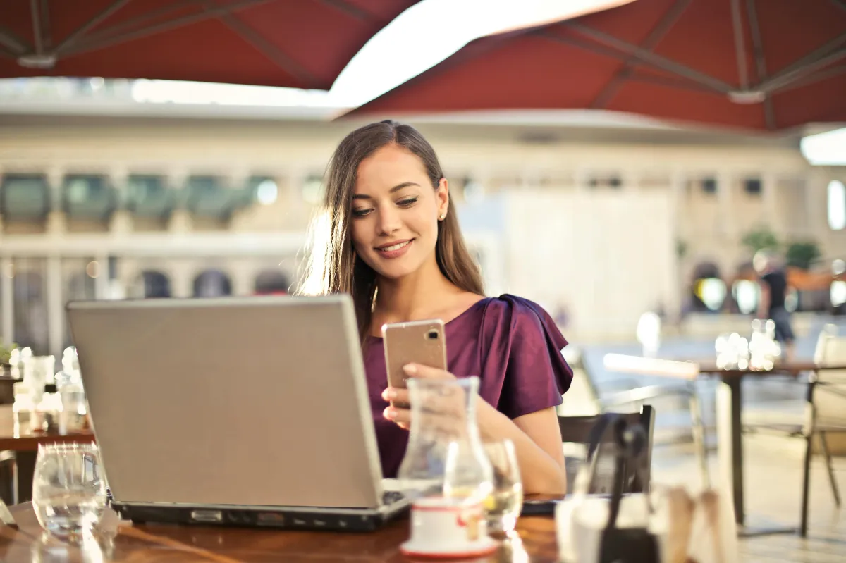 Happy woman on her cell phone and laptop