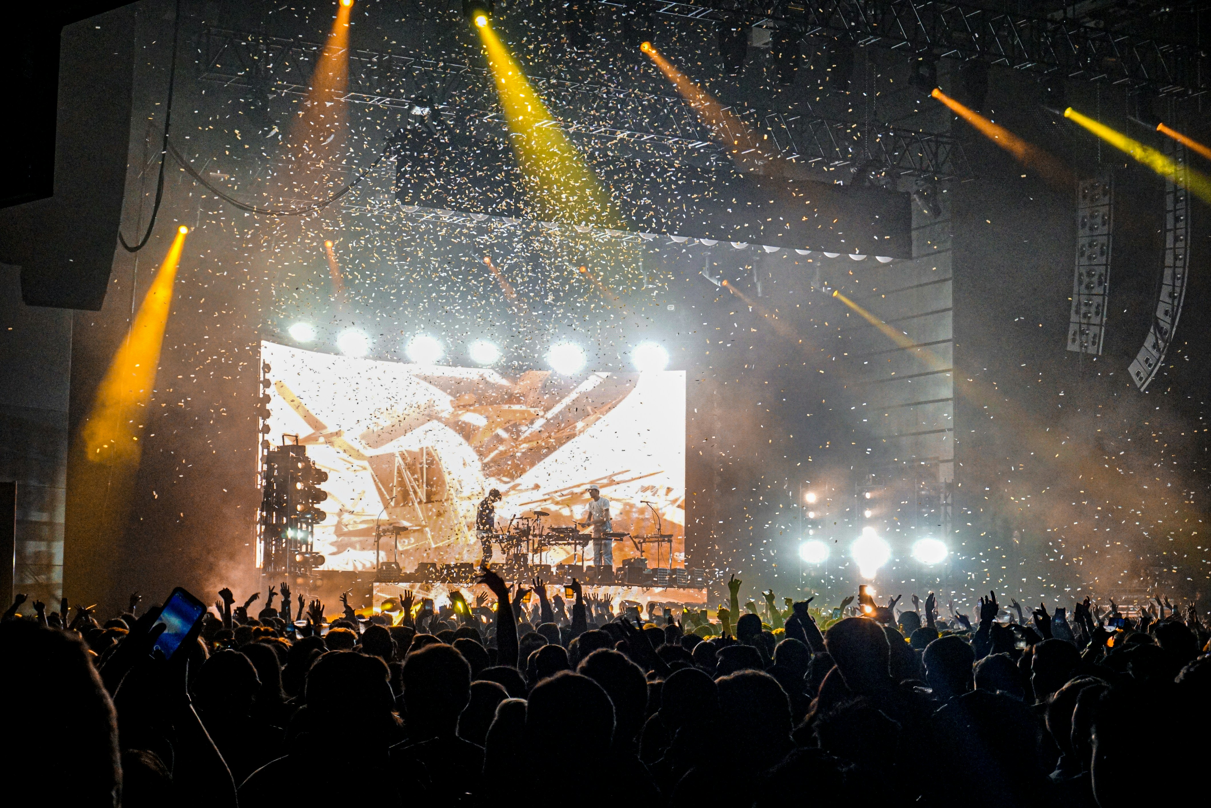 Concert crowd with hands up and stage lights