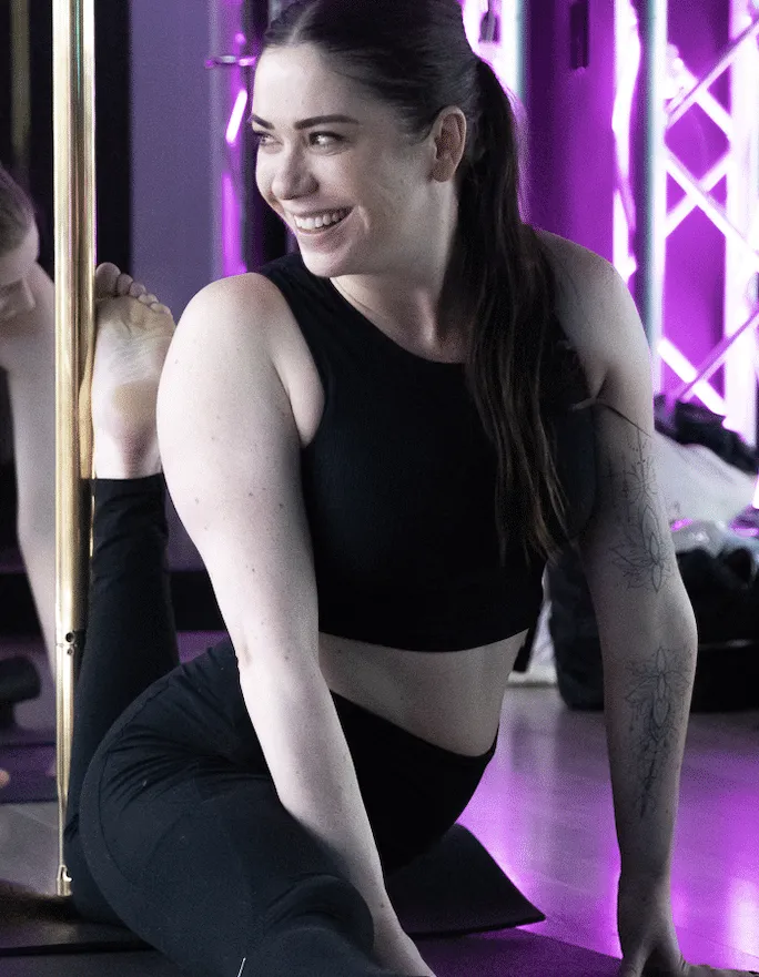 pole instructor in splits with smile 