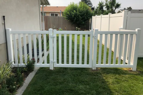 white vinyl picket fence and gate on the side of a house