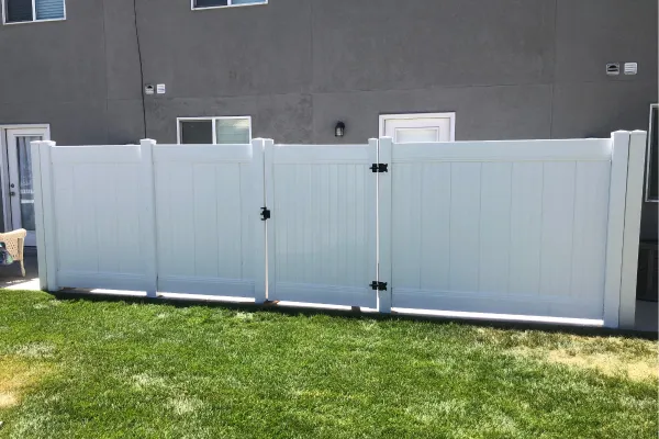 white vinyl fence with a gate in a backyard