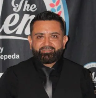 Mentora barbera joven, cabello corto y teñido, piel clara, fondo neutro beige, sonrisa cálida, estilo retrato 1:1, composición centrada, transmite energía y modernidad.