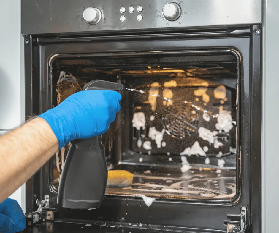 SuperMaids spraying cleaner inside an oven