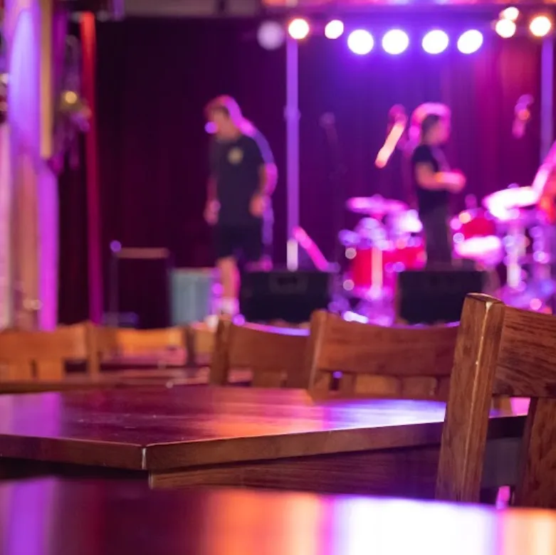 view of tables and stage inside the adelphia music hall