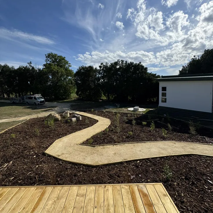 Curved timber path and newly planted garden beds showcasing landscaping services in Hastings, Hawke's Bay by Mitch's Maintenance
