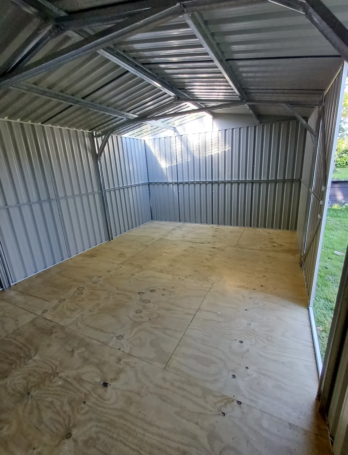 Inside view of newly assembled metal kitset shed with timber floor, highlighting kitset assembly services in Hastings, Hawke's Bay by Mitch's Maintenance