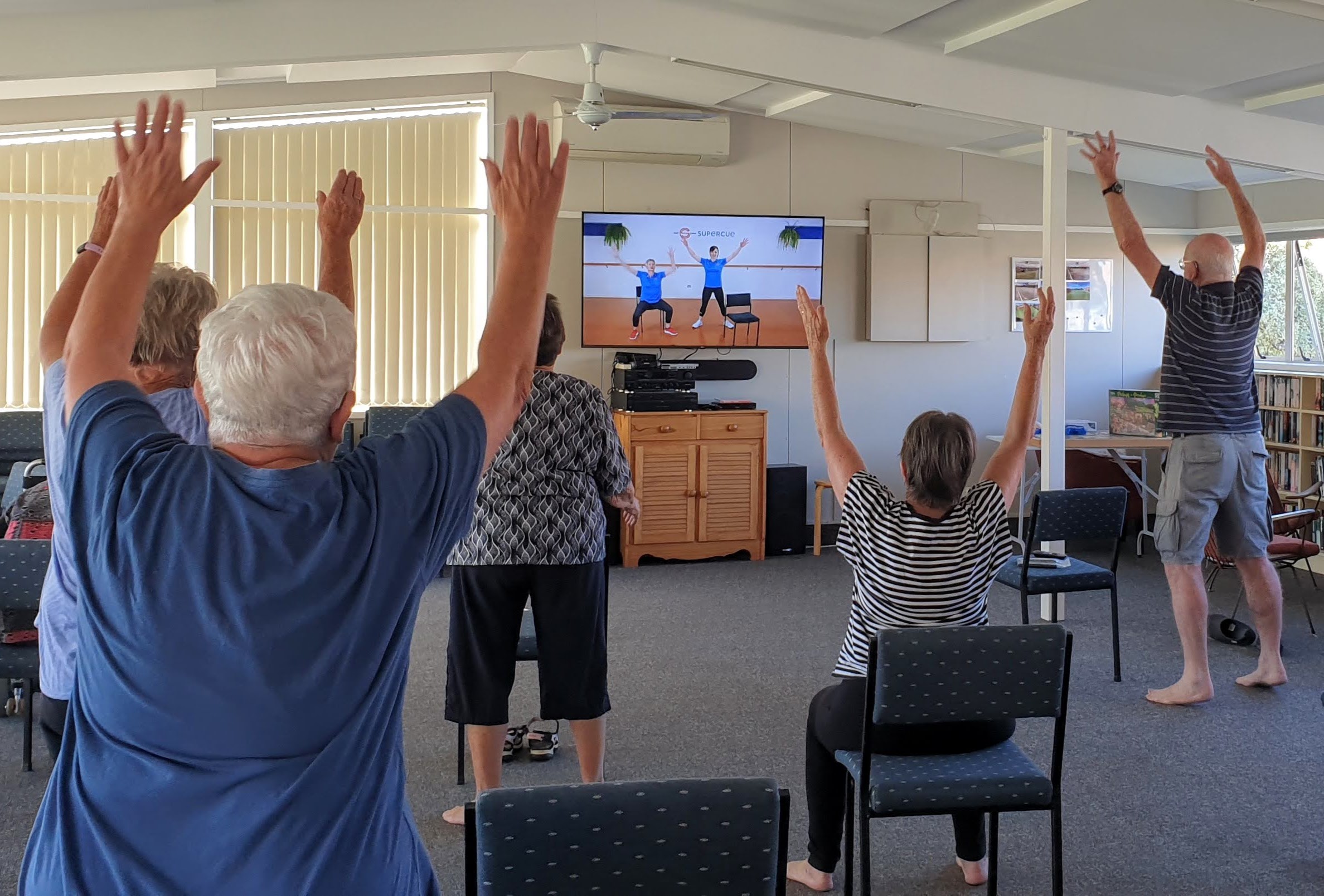 Smiling people exercising together in a bright fitness studio