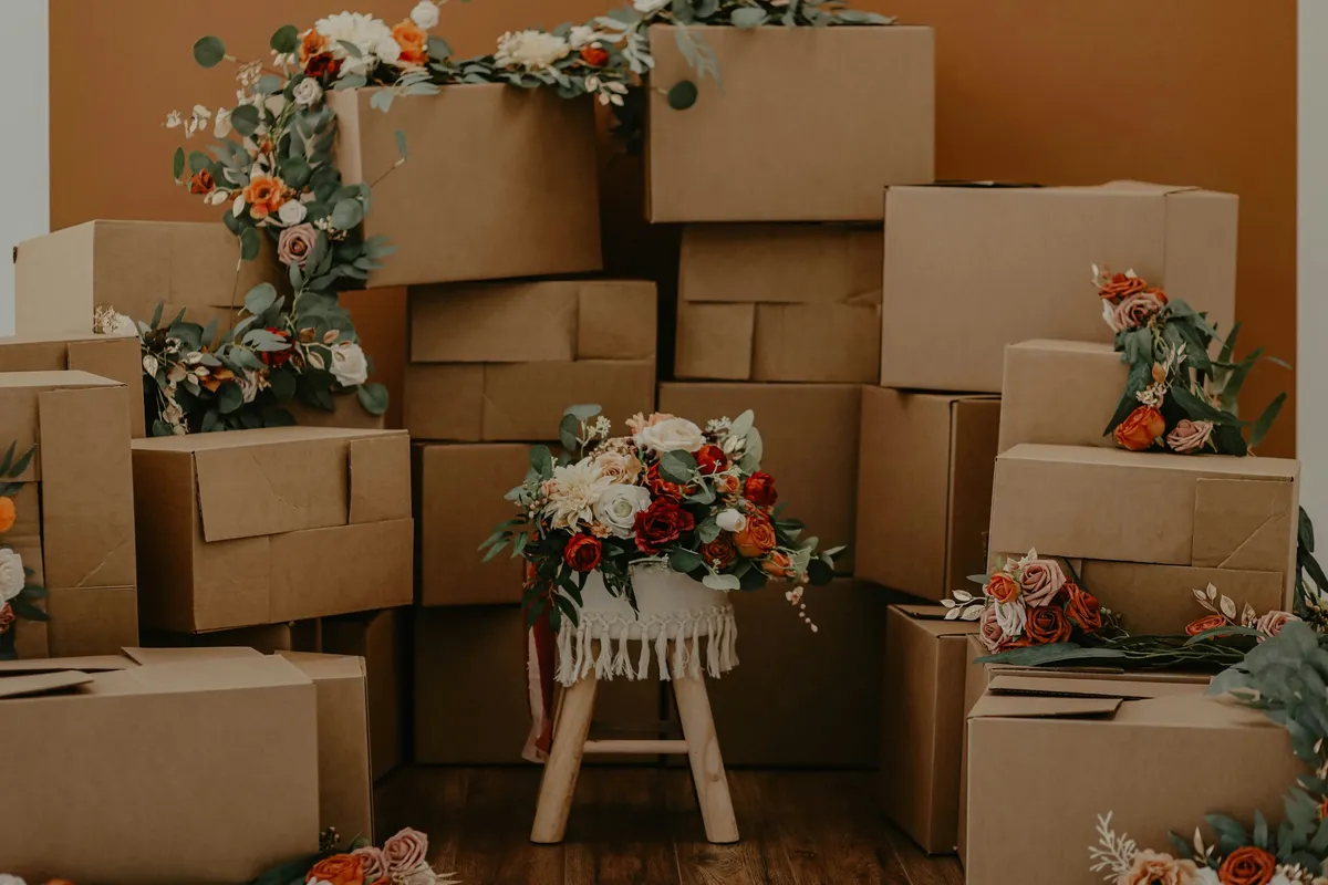 Stacked moving boxes decorated with fresh flowers, ready for a move to a new home.