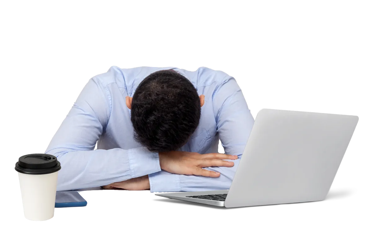 Business owner feeling overwhelmed with head down on desk in front of a laptop, symbolizing burnout and frustration.