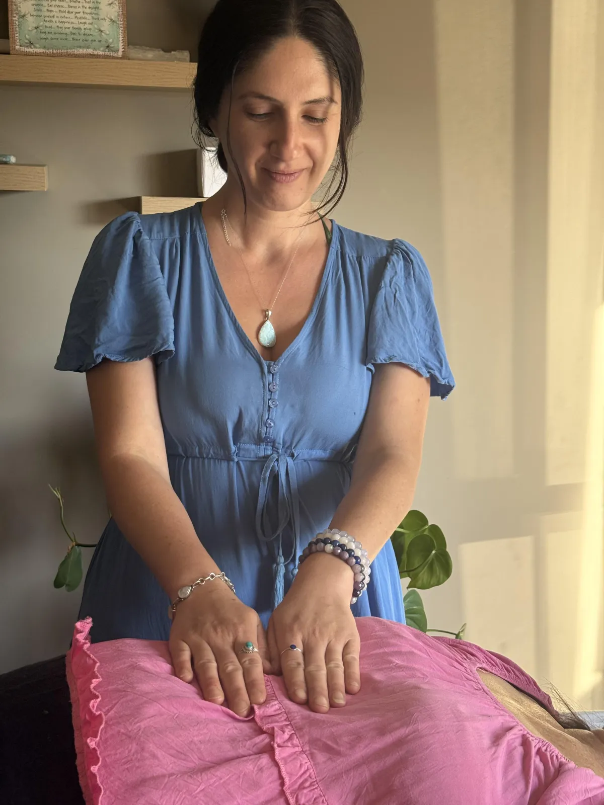 Soft-focus somatic image of hands near a body or botanical element