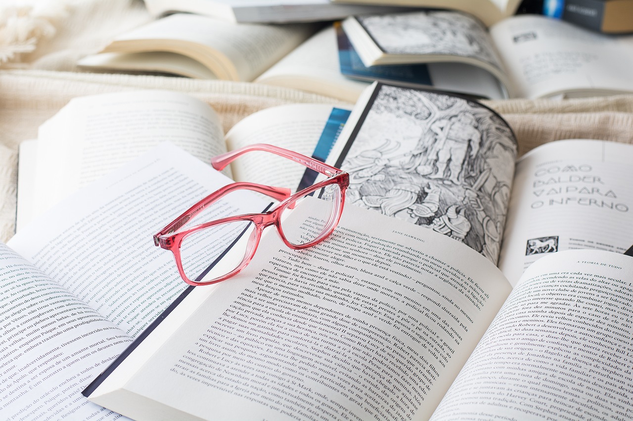 picure of pink glasses on a pile of open books