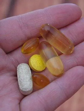 a hand full of vitamin supplements pills