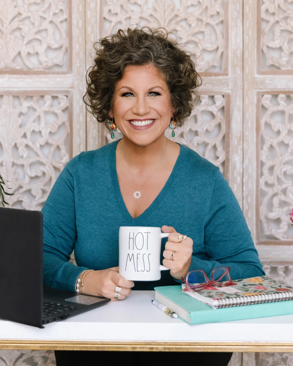 stacy behind a desk with computer books and mug