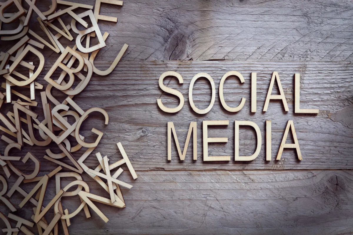 The word social media is created using the alphabets on a wooden plank
