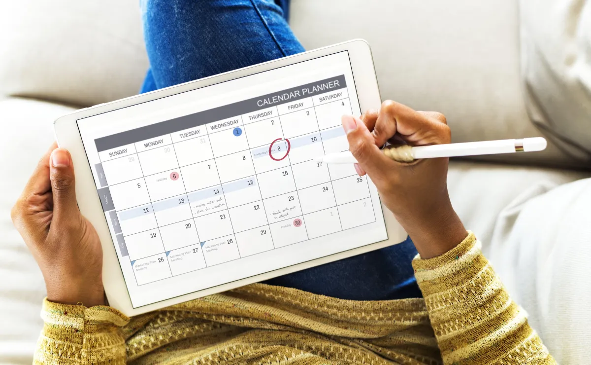An individual checking the calendar in the tablet