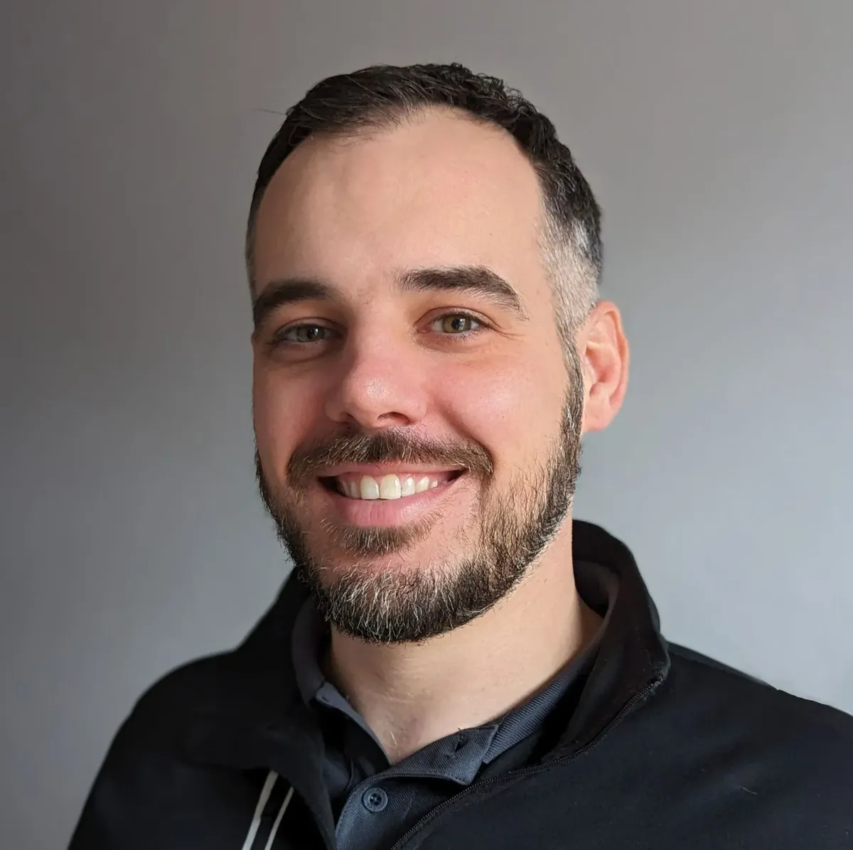 Professional headshot of Joey Metz, smiling warmly, against a neutral background
