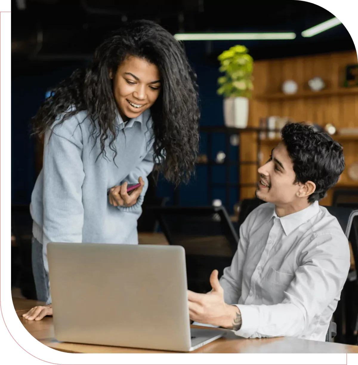 Business professionals collaborating at a laptop while reviewing AI automation tools.