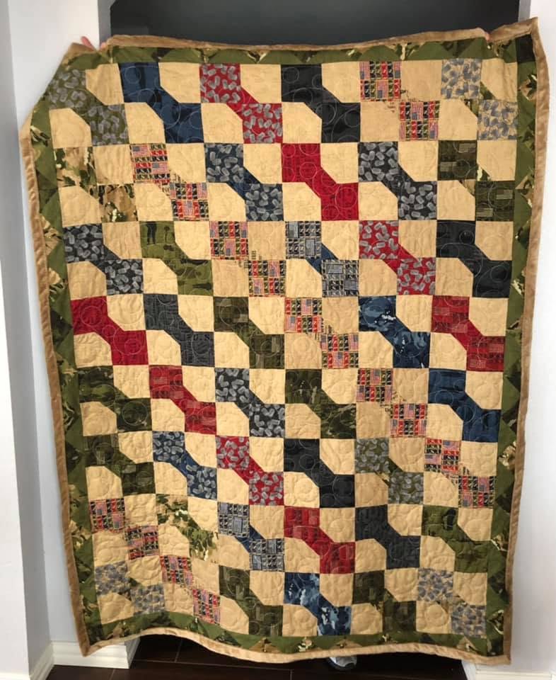 A warm and inviting memory quilt draped over a chair.
