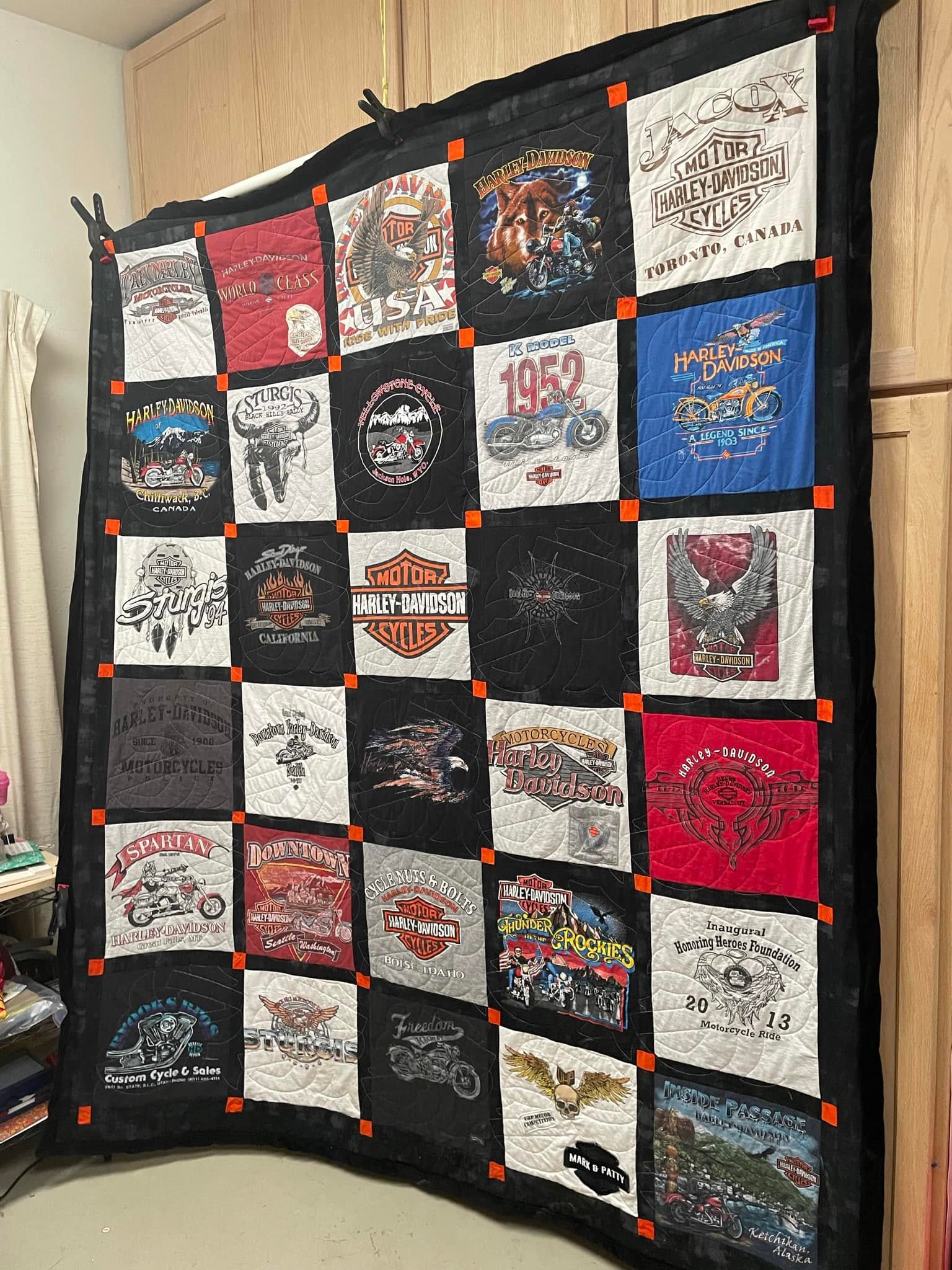 A large completed custom quilt showing diverse clothing swatches.