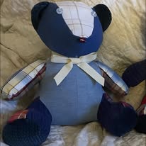 A beautiful, handcrafted memory bear made from meaningful clothing, sitting softly in natural light.