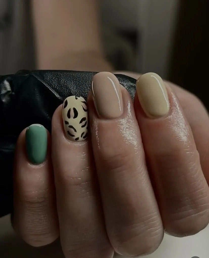 Sage green and neutral nails with a leopard-print accent, by Beauty by Amy