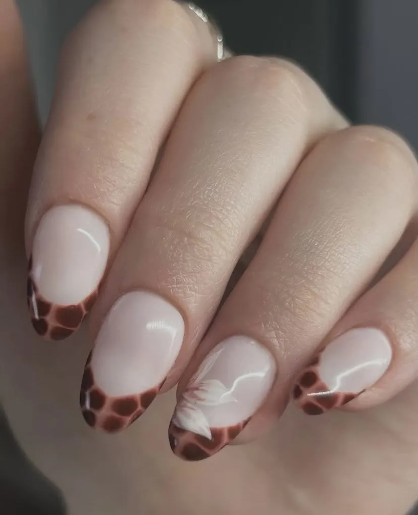 Tortoiseshell French tips with a white floral accent, by Beauty by Amy
