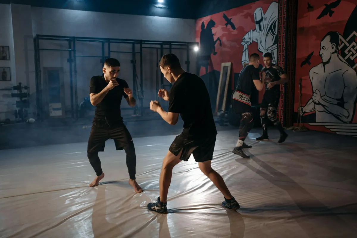 A GROUP OF STUDENTS SPARRING IN A COMBAT GYM