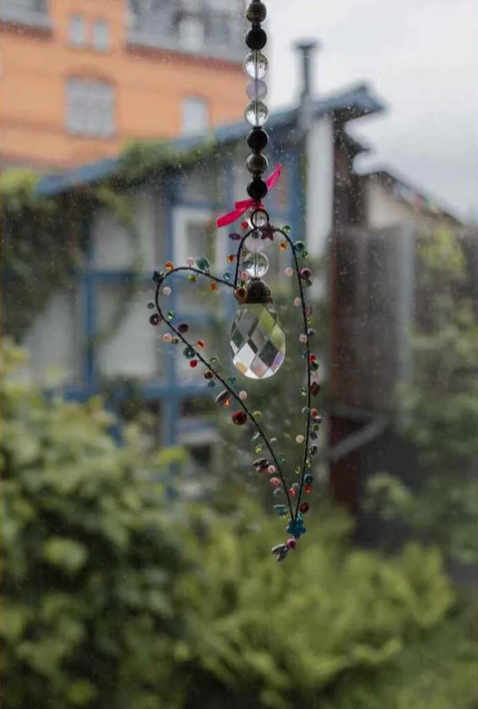 Blick aus dem Fenster mit einem Bergkristallherz aus der Mental Coaching Praxis Kerstin Waterman in Idstein.