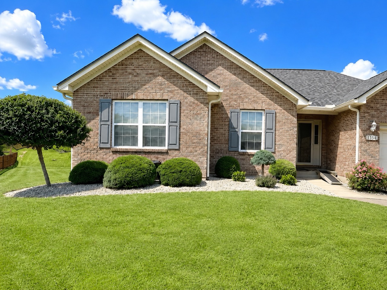 Front yard landscape rock beds with trimmed shrubs and clean residential curb appeal maintained by Earl’s Lawn Service in Union, Kentucky.