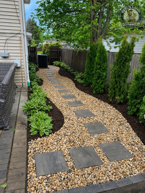 Curved river rock garden path with stepping stones, hostas, mulch beds, and privacy shrubs in Fort Mitchell, KY.