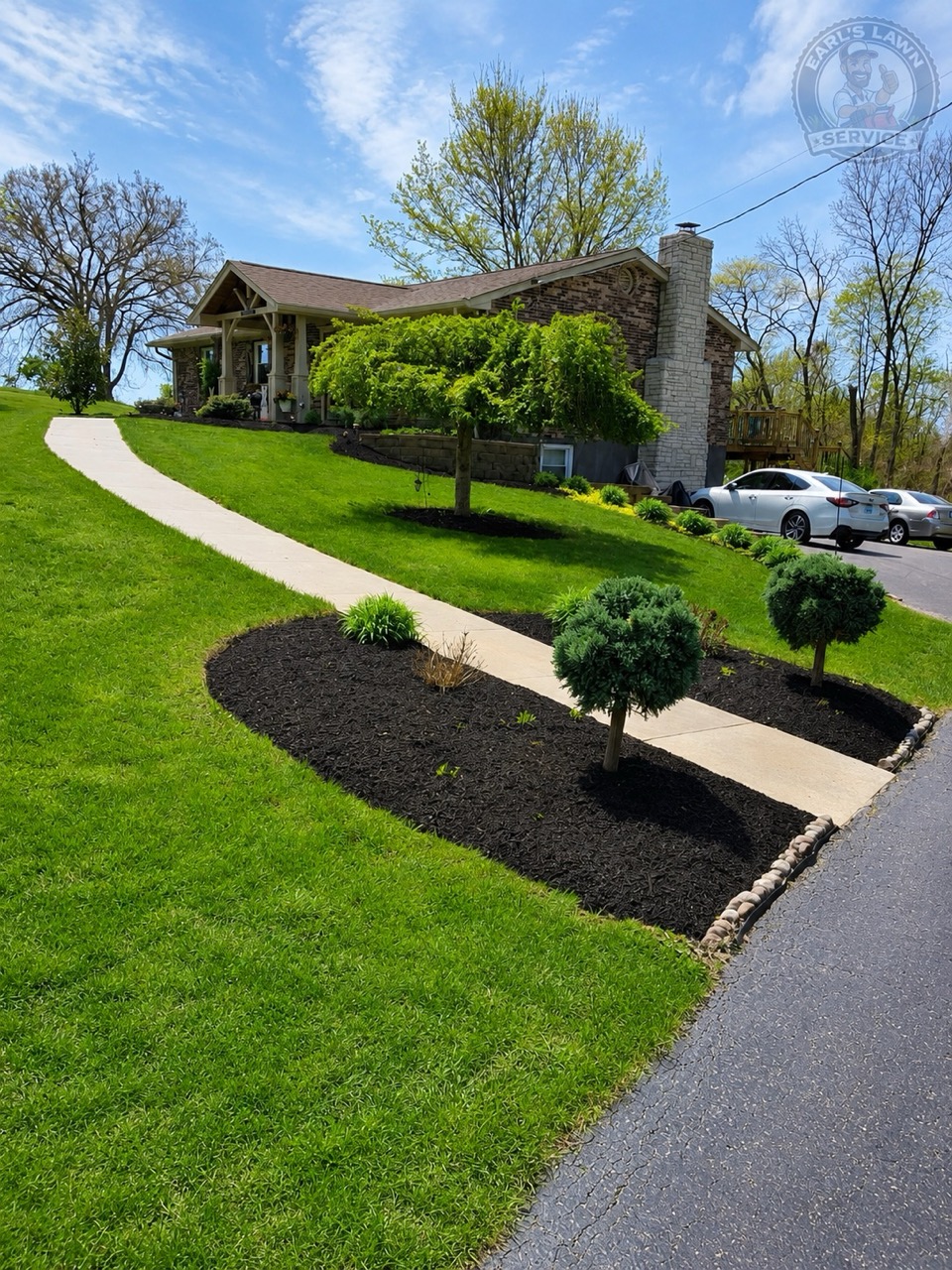 Freshly cut lawn with dark mulch beds, trimmed shrubs, and clean edging at a Northern Kentucky home