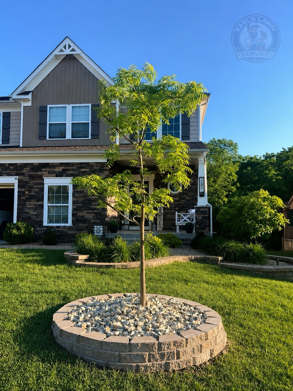 Front yard landscaping with decorative stone, circular tree border, and maintained lawn at a Northern Kentucky home