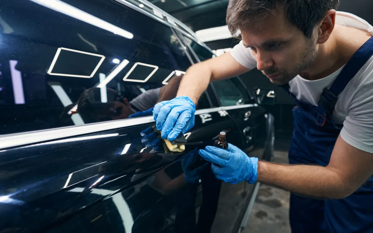 A man applying a ceramic coat on a car