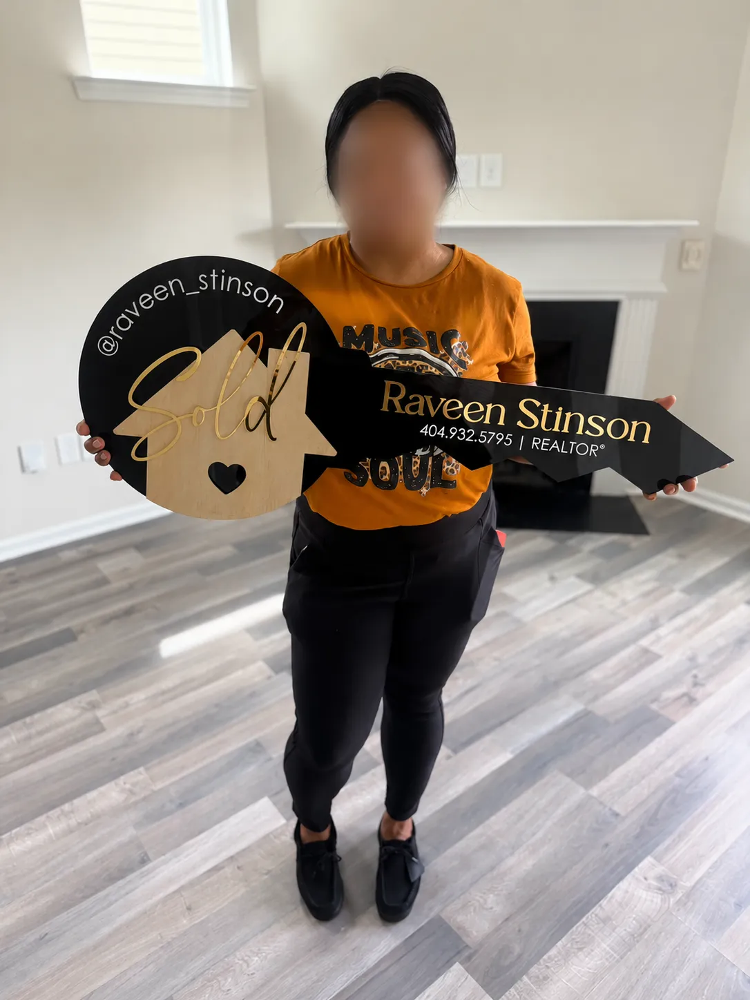 Homebuyer celebrating her closing with a SOLD key; face blurred for privacy.