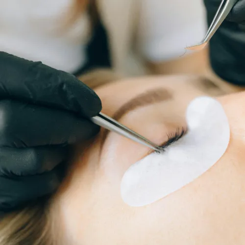 Eleganter Lippenstift in Rosé-Gold-Hülse, stehend auf poliertem Glas, mit sanftem Licht und dezentem Schatten. Realistische Fotografie, 1:1-Format.