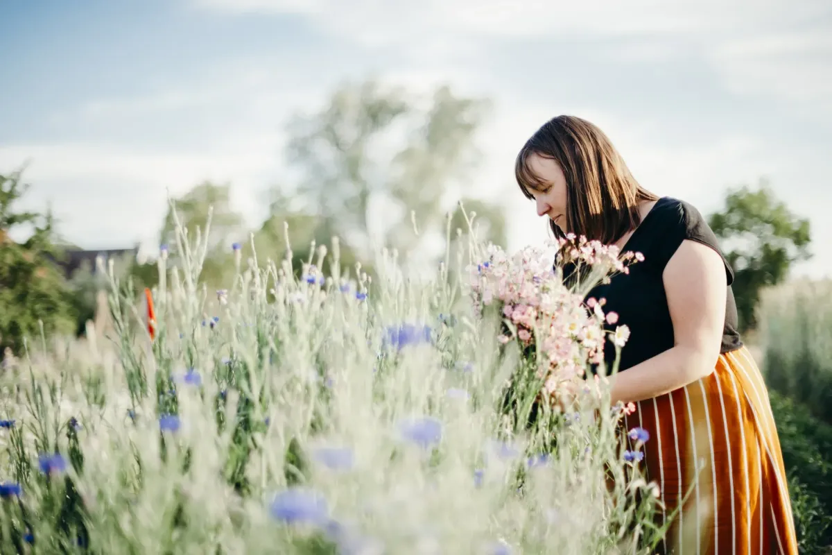 Portrait of the farmer tending rows with watering can, natural candid expression, evening light, authentic connection.